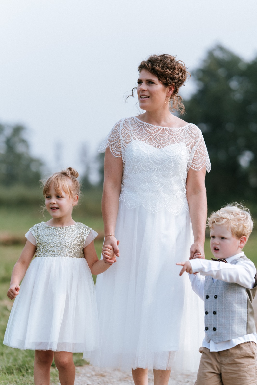 Bruid met haar twee kinderen buiten op het gras