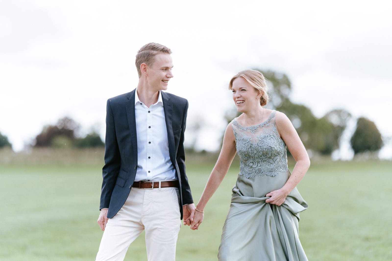 Bruidspaar loopt hand in hand over het gras