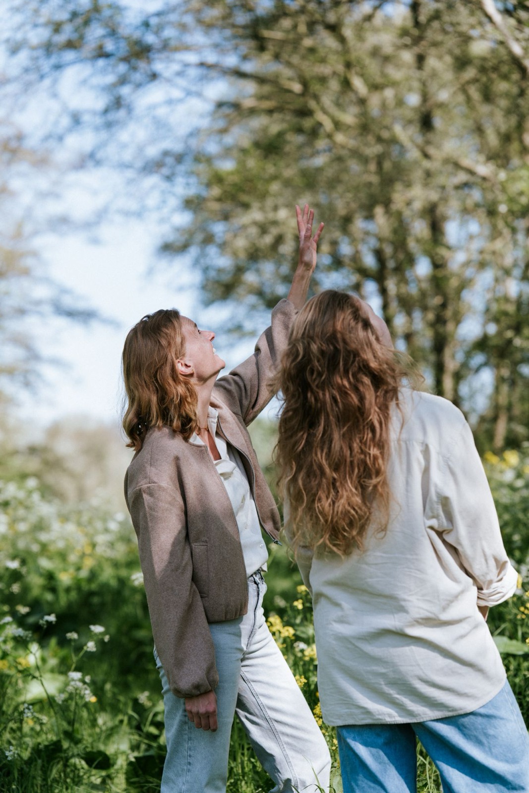 Ellen en een deelnemer kijken lachend omhoog naar de bomen
