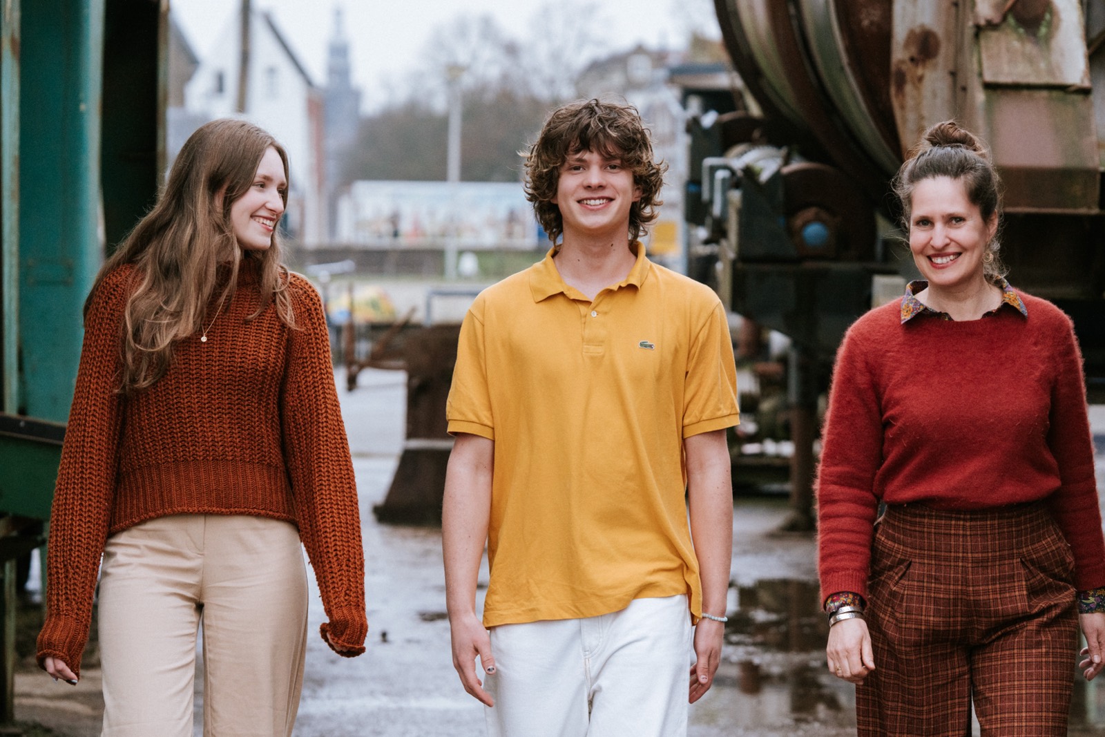 Moeder met twee tieners wandelend langs een industriële locatie