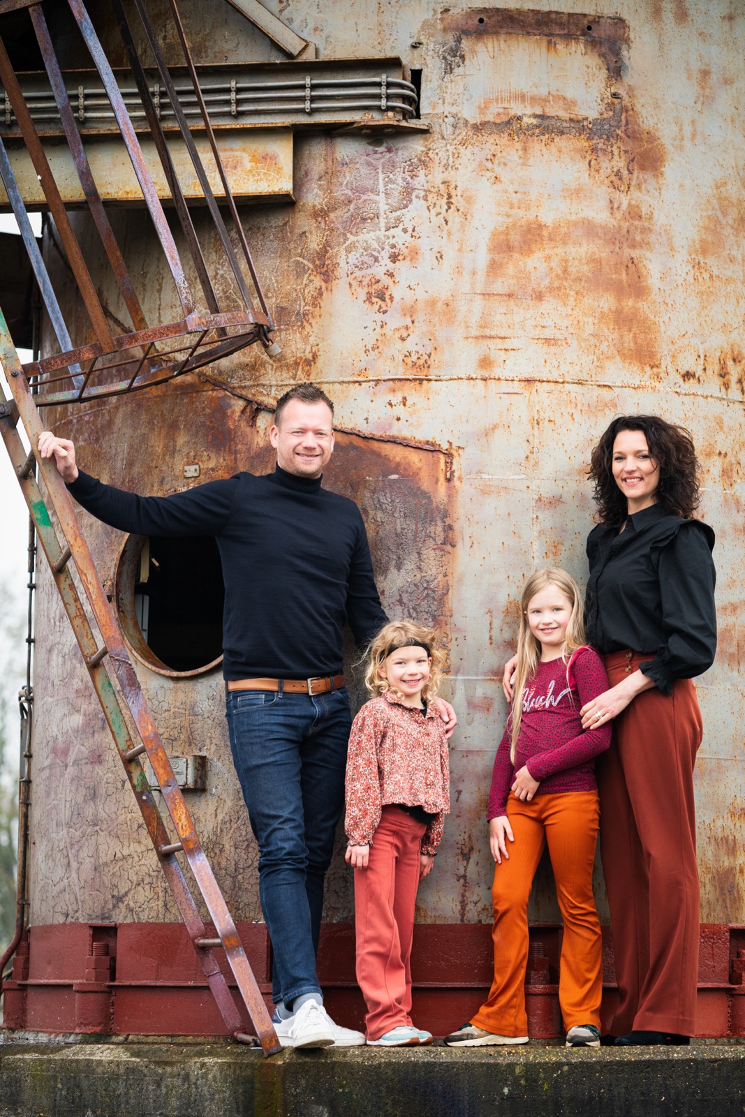 Gezin met twee dochters voor een roestige oude silo