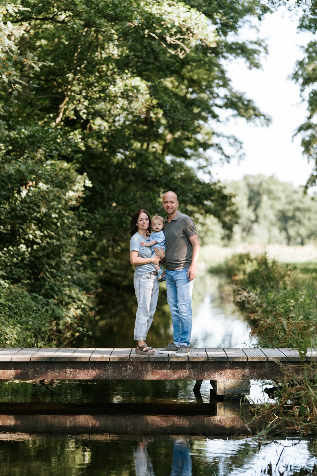 Ouders met hun baby op een houten steiger aan het water