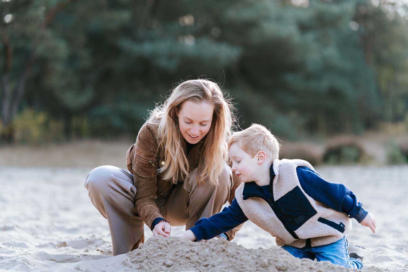 Moeder en zoontje spelen samen in het zand