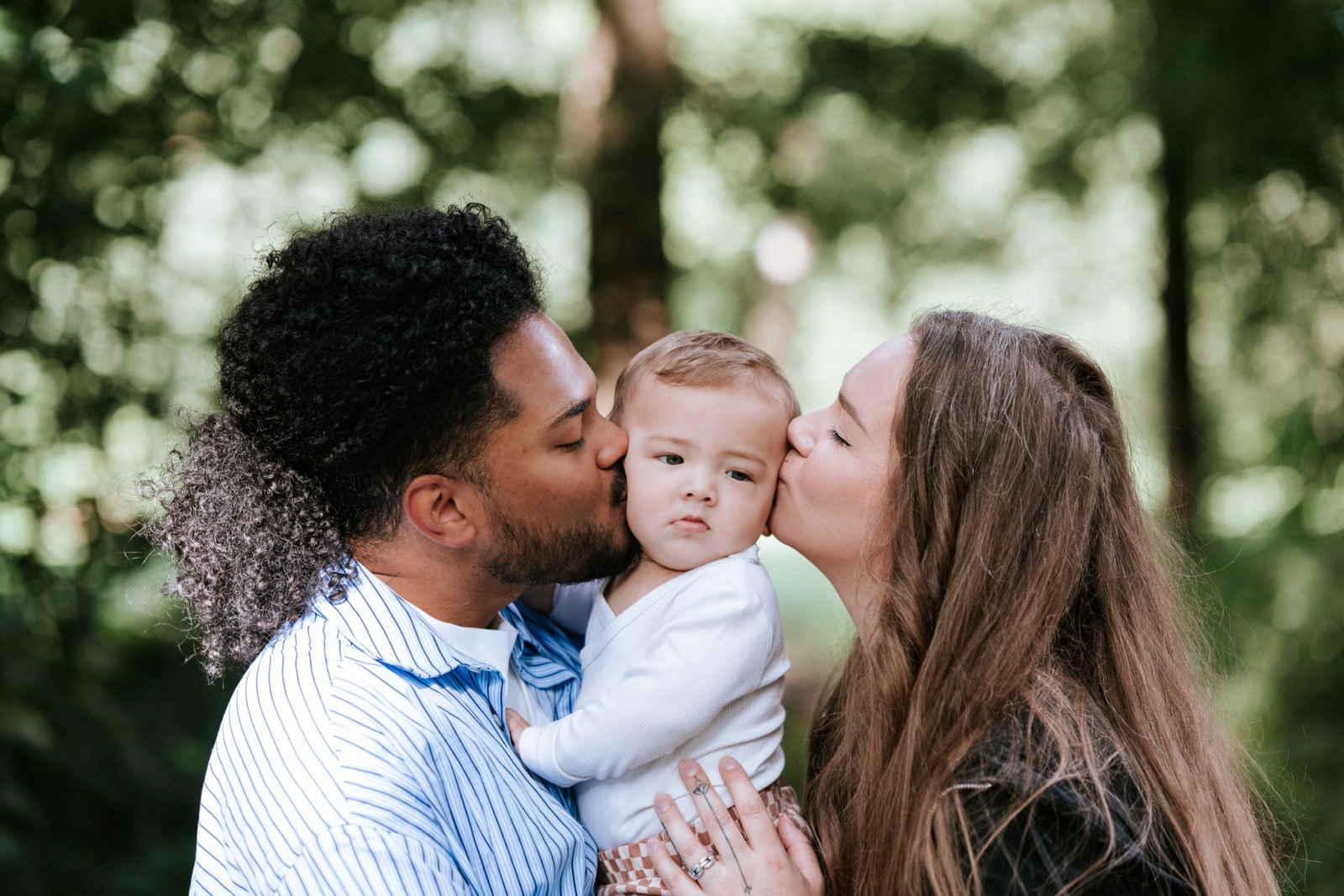 Ouders kussen hun baby tegelijk op beide wangen