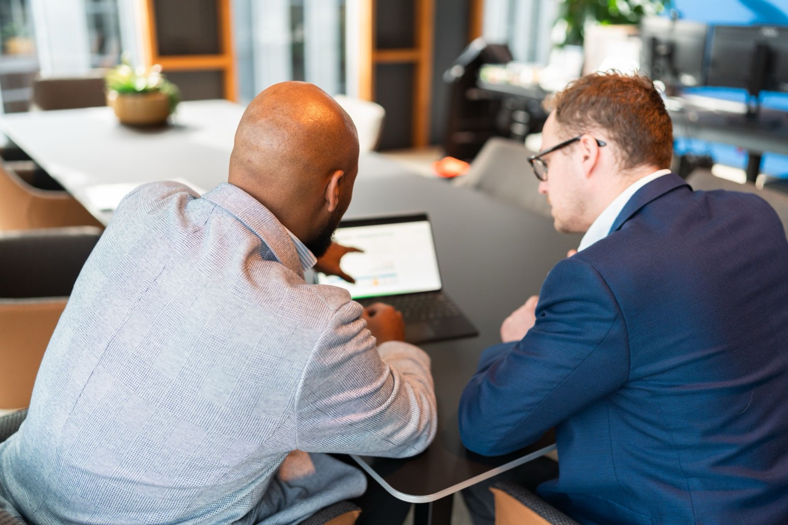 Twee collega’s van Farminform bekijken samen cijfers op een laptop