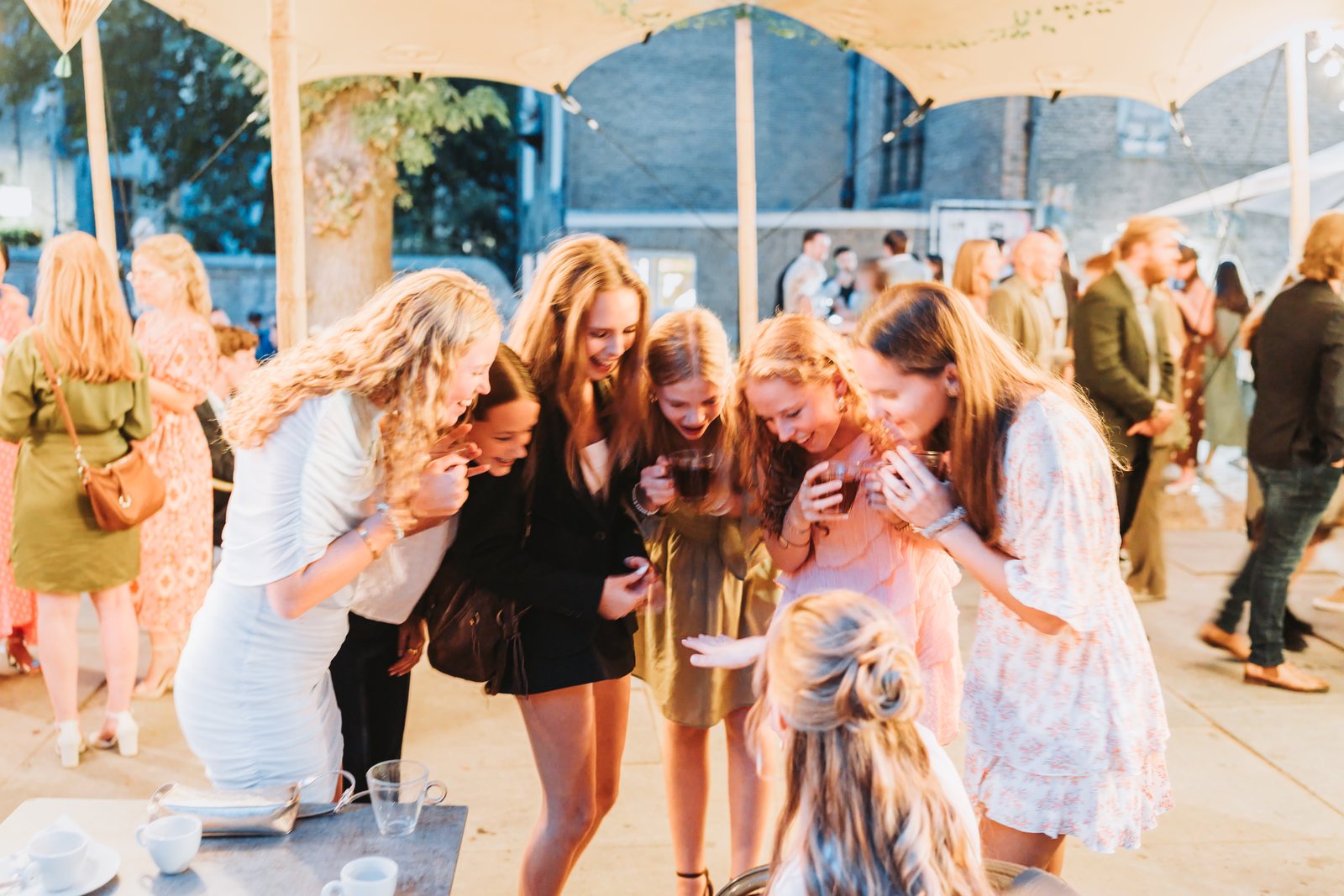 Bruid lacht met vriendinnen tijdens het feest