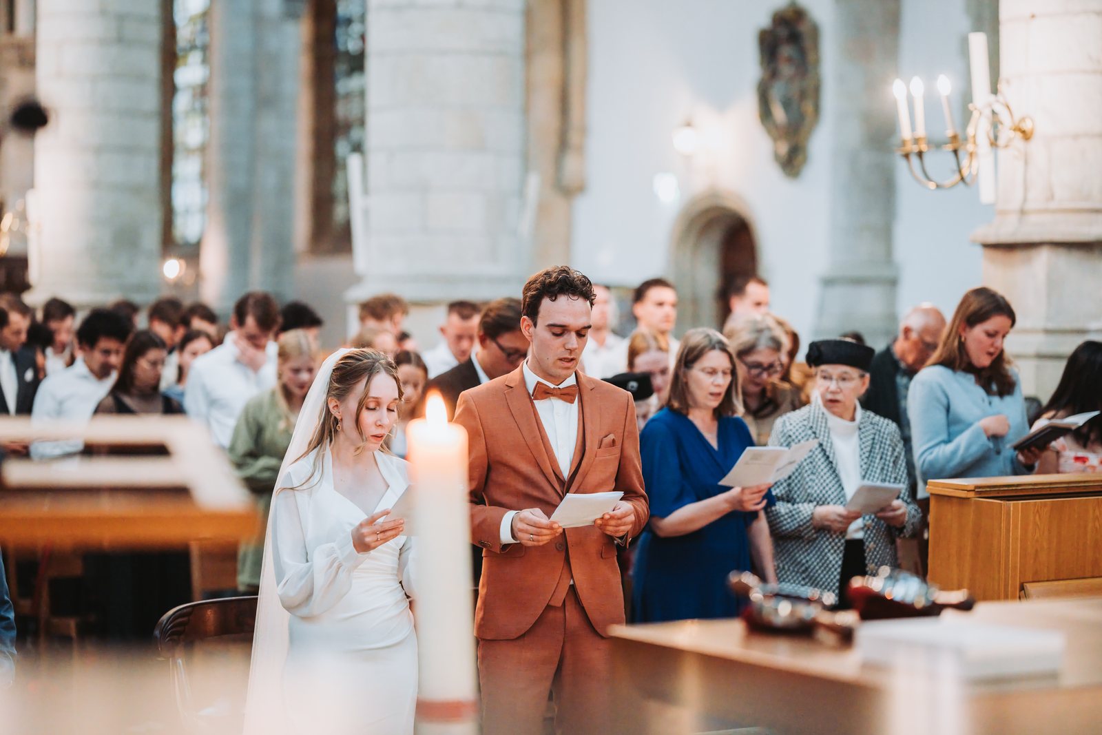 Bruidspaar zingt mee tijdens de kerkdienst