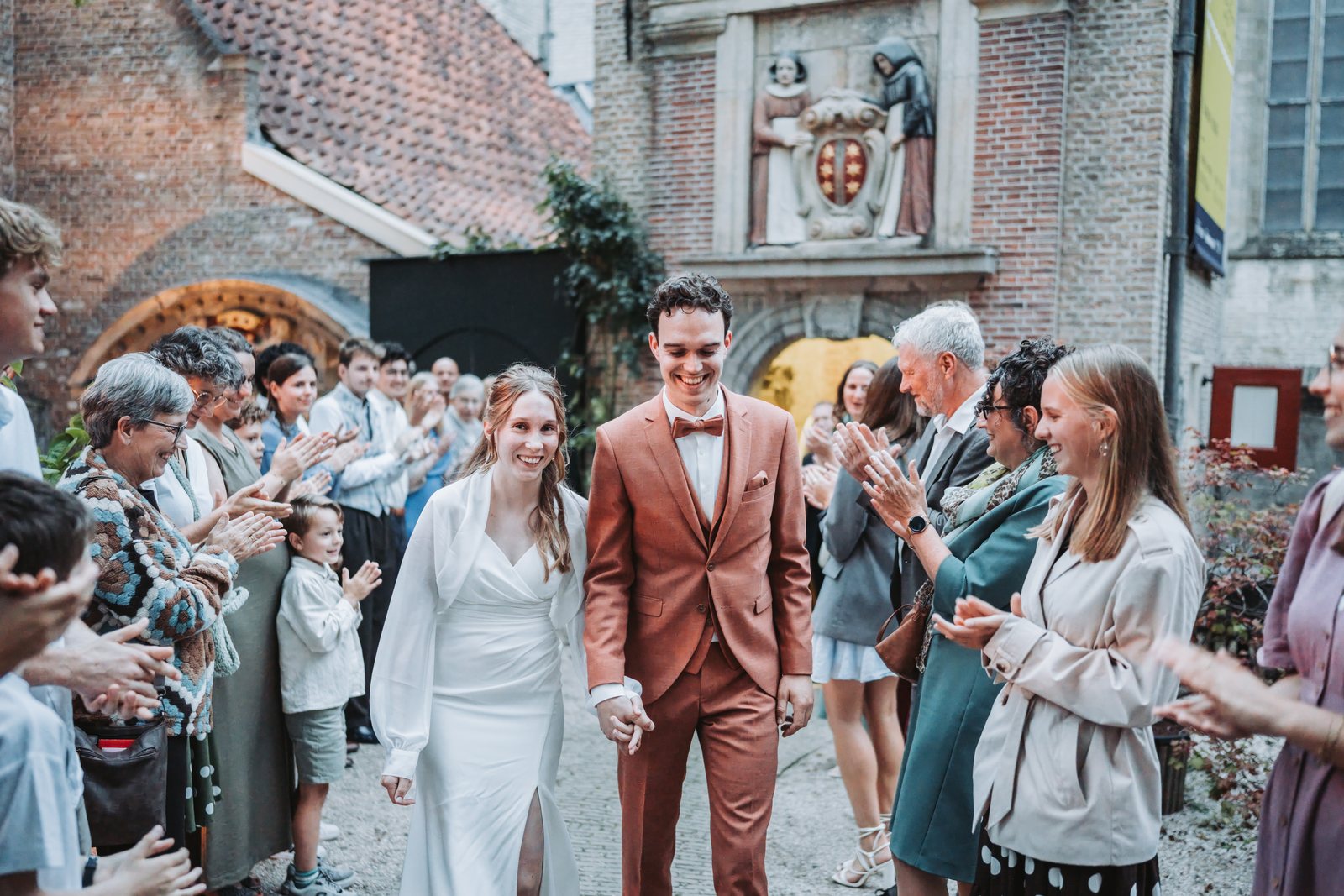 Gasten klappen voor het bruidspaar bij het Lazaruspoortje in Gouda