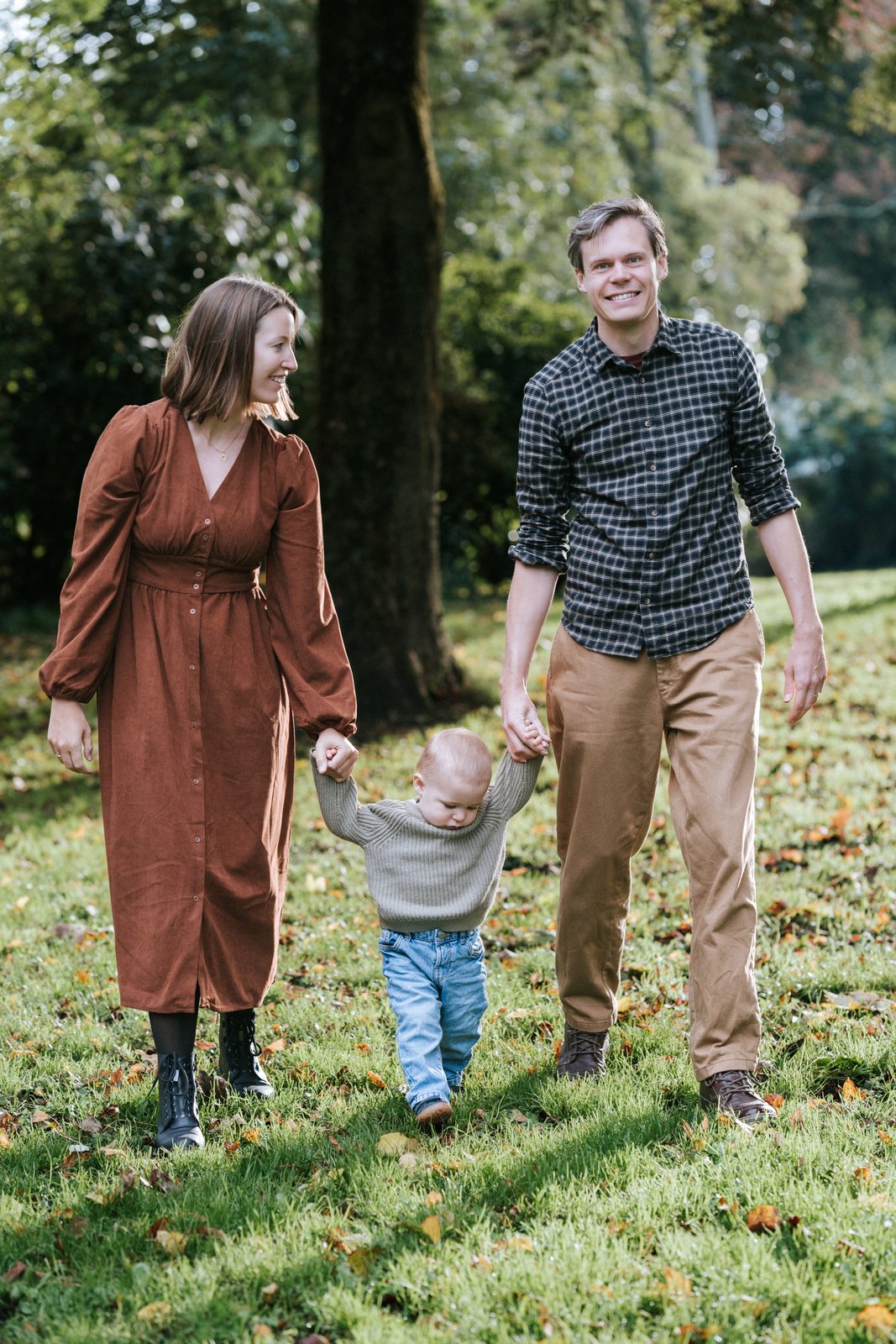 Zoontje loopt aan de handen van zijn ouders door het Houtmans Plantsoen