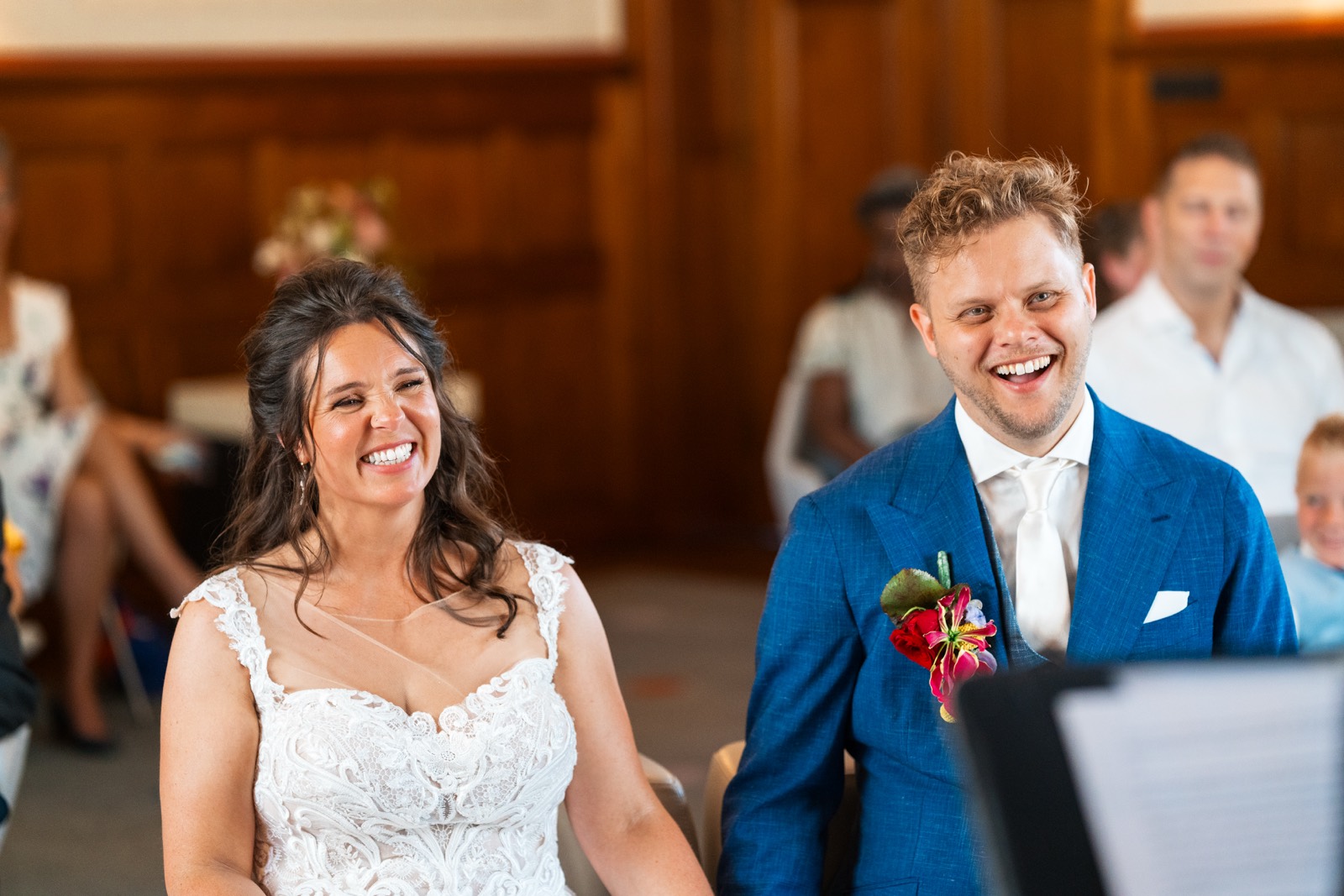 Bruid en bruidegom lachen tijdens de ceremonie in de trouwzaal