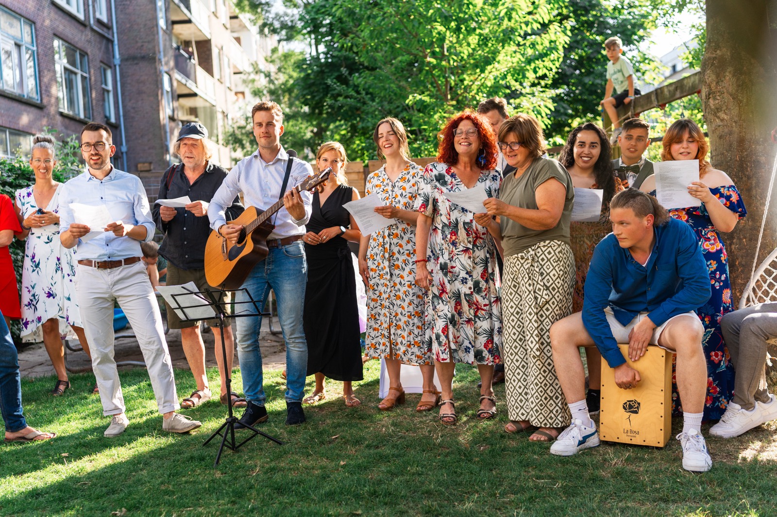 Vrienden en familie zingen met gitaar en cajon voor het bruidspaar