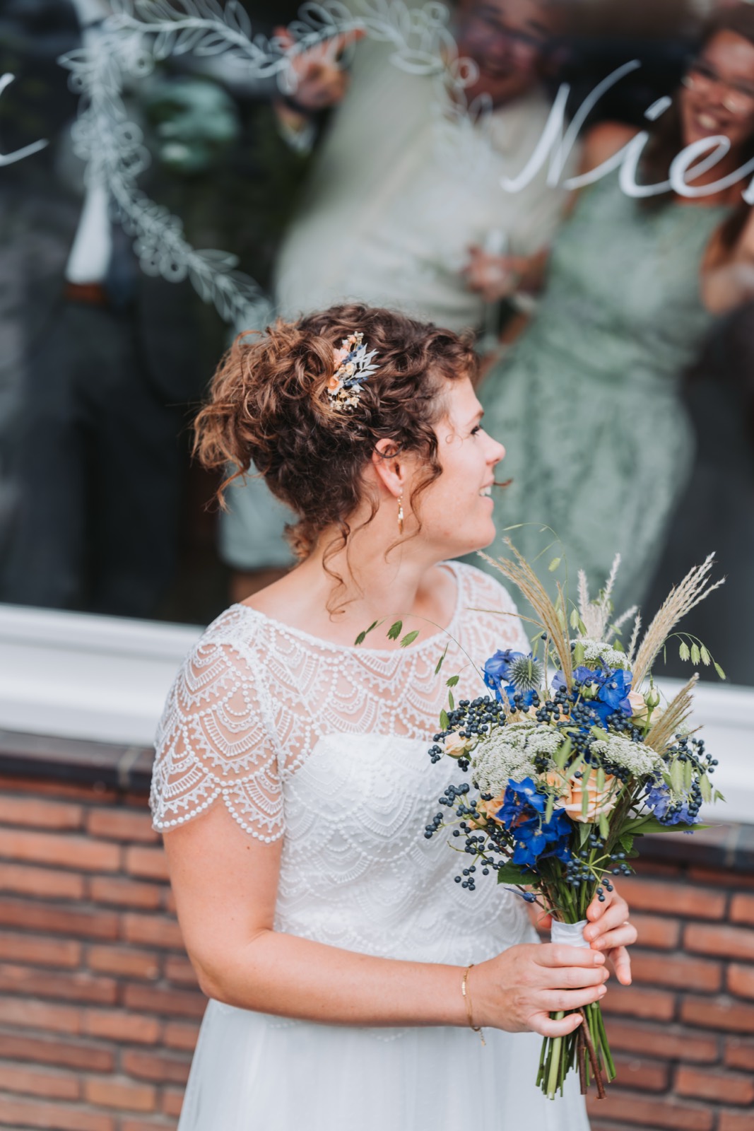 Bruid met haar boeket bij het raam