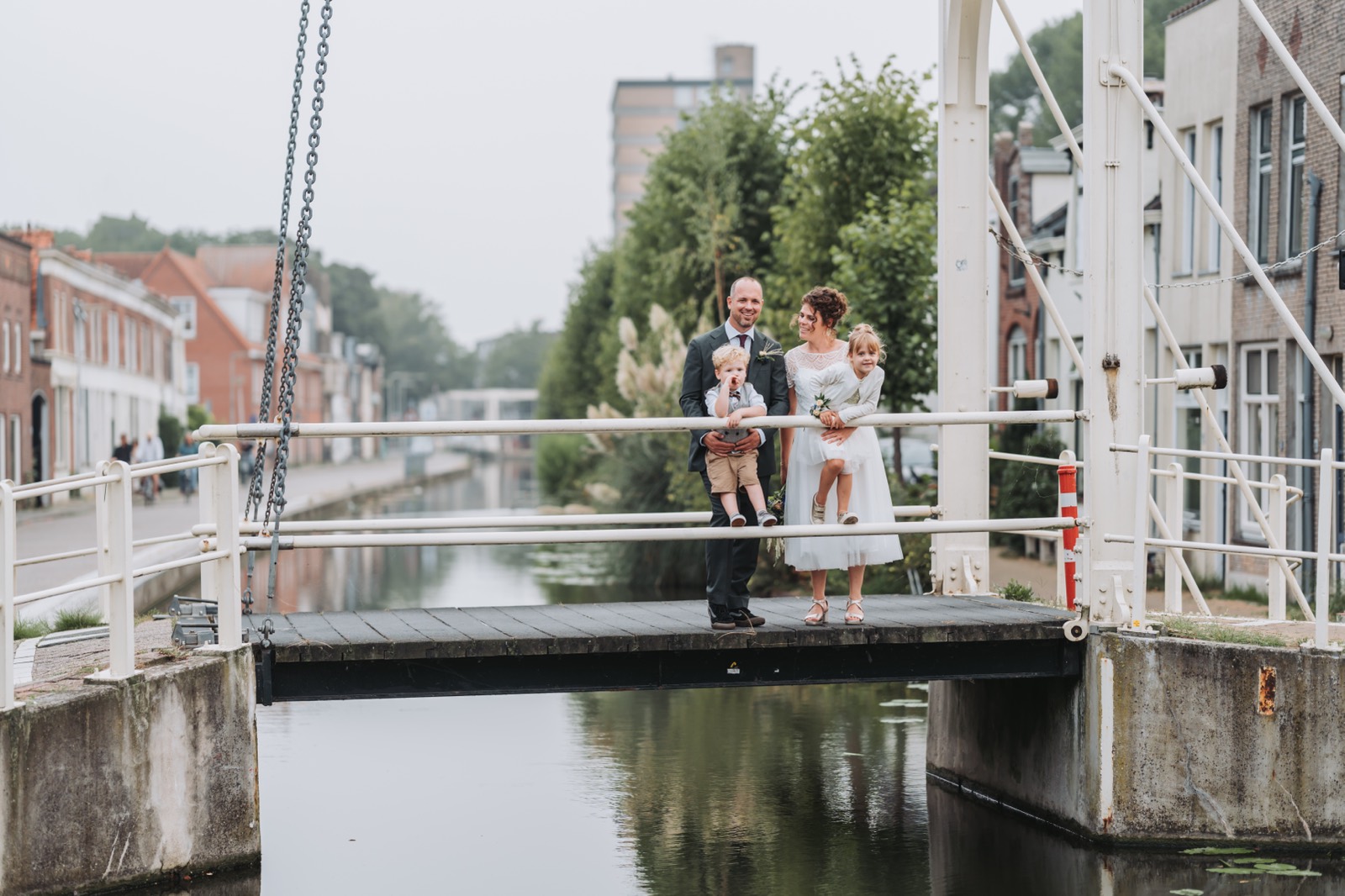 Bruidspaar met de kinderen op een ophaalbrug in Gouda