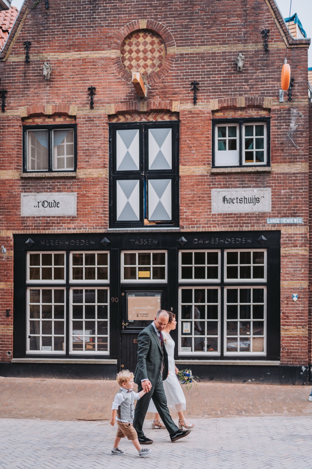 Bruidspaar loopt langs een historisch pand in Gouda