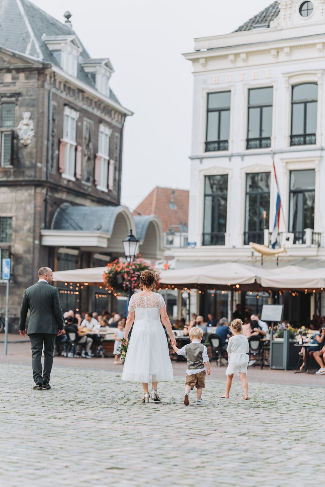 Bruidspaar met de kinderen op een plein in de binnenstad van Gouda
