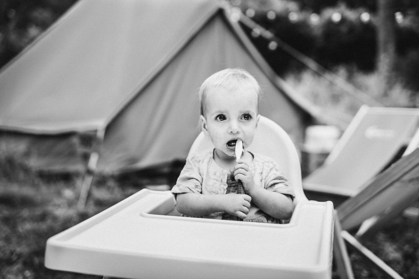 Meisje met een lepel in haar mond voor een tent