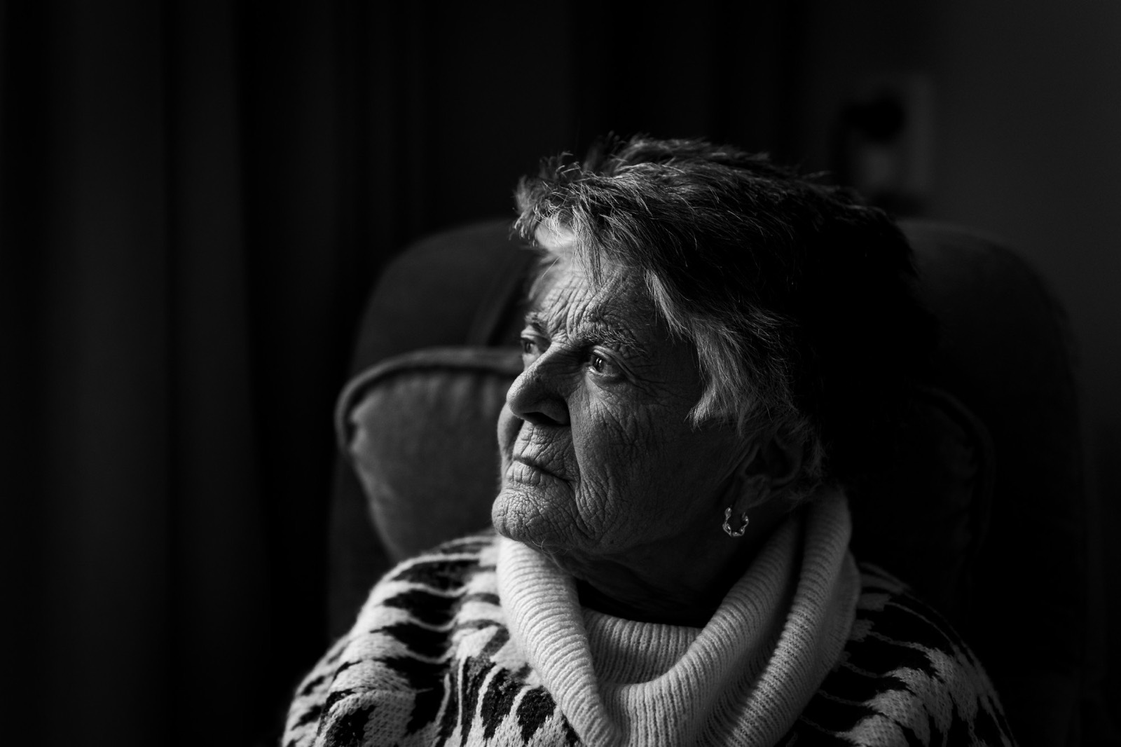 Zwart-witportret van een oudere vrouw die peinzend opzij kijkt