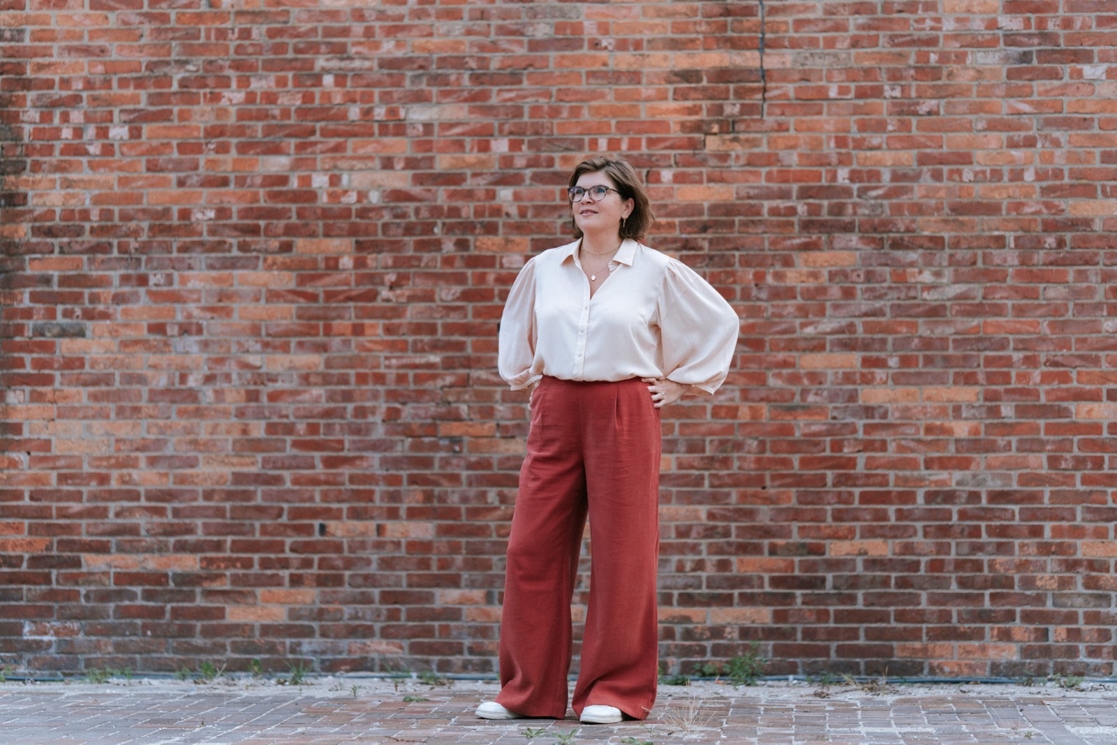 Zakelijk portret van een vrouw voor een bakstenen muur