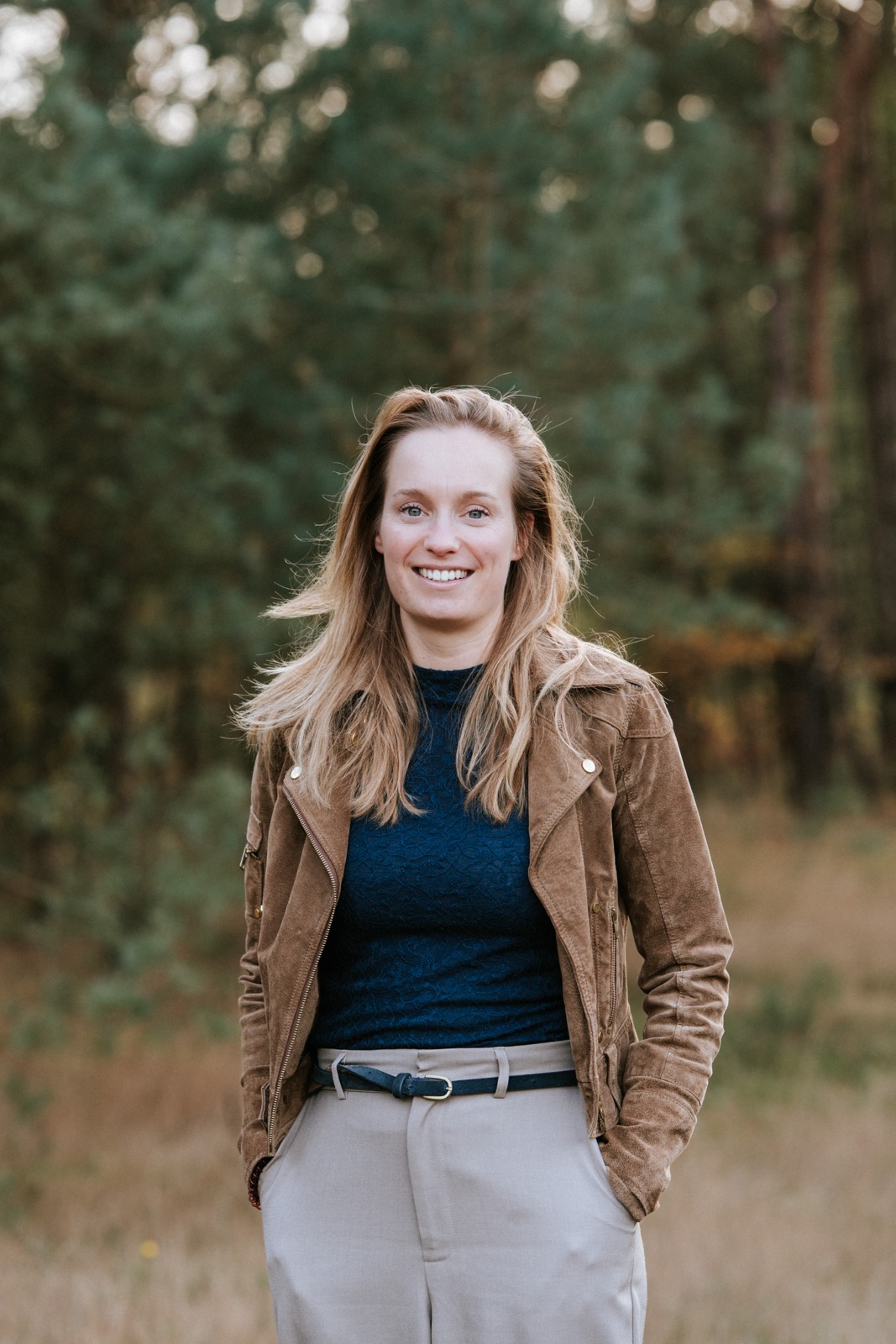 Zakelijk portret van een vrouw in een bruin jasje in het bos