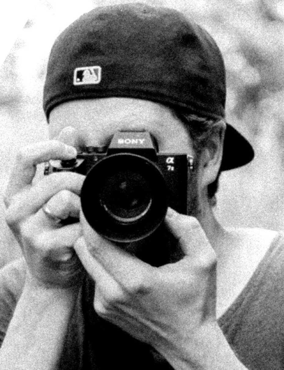Zeb van Drie fotografeert met zijn camera, in zwart-wit